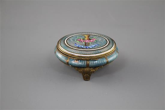A late 19th century gilt metal and enamel oval box, decorated with a basket of flowers,